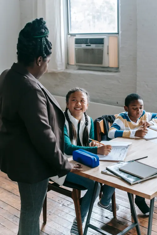 Smiling girl student with her teacher during a lesson