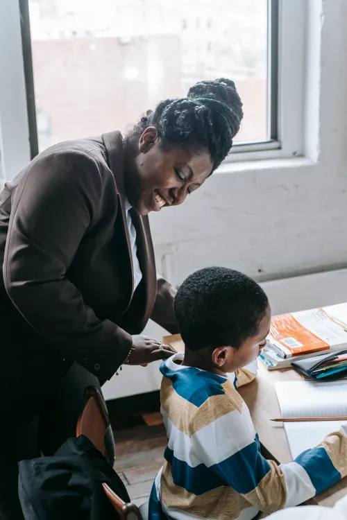 Smiling teacher working with a young student